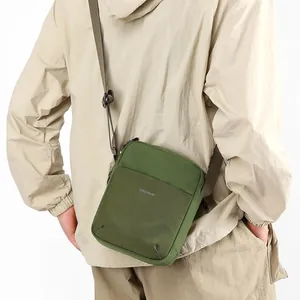 Olive green nylon crossbody bag for casual travel, shown being worn by a model