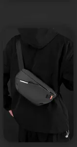 Detailaufnahme der schwarzen Brusttasche mit mattem Finish und orangem Gurtband