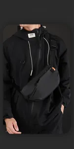 Detail der wasserdichten Funktionsbrusttasche mit orangefarbenen Zippern und Steckschnalle