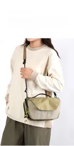 Close-up of minimalist khaki and olive green crossbody bag with geometric grid texture