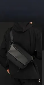 Detail of waterproof black messenger bag with adjustable strap and techwear aesthetic