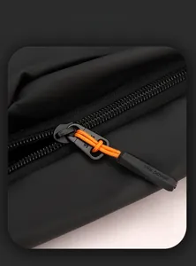 Detailaufnahme des schwarzen Reißverschlusses mit oranger Kordel am We power Rucksack