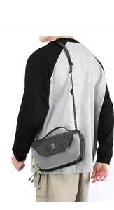 Detail of grid patterned crossbody bag showing the adjustable strap and logo branding