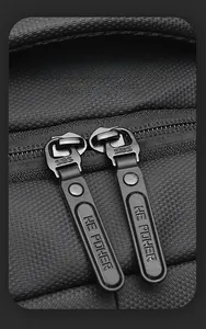 Detail of durable dual SBS zippers with HE POWER logo on black textured fabric backpack