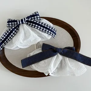 Detail of plaid and denim bow hair clips with multi-layered white floral lace edges