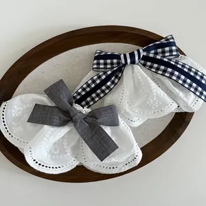 Detail of Korean lace bow hair clips with navy plaid and grey fabric on wooden tray