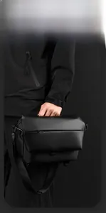 Detail of matte waterproof messenger bag with embossed logo and wide adjustable strap