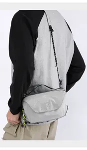 Detail of grey grid crossbody bag showing waterproof zipper and minimalist logo