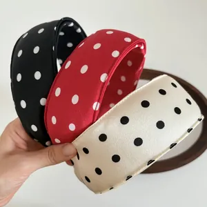 Detailed close-up of wide polka dot sponge headbands in black, red, and cream satin fabric