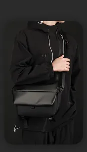 Close-up of black tactical messenger bag with adjustable strap and waterproof fabric