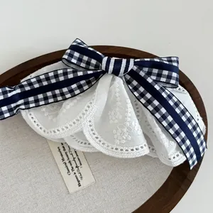 Detail of navy plaid bow with triple-layered floral embroidery lace and scalloped edges