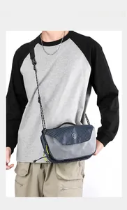 Detail of blue and grey waterproof nylon crossbody bag with adjustable strap and plastic buckle