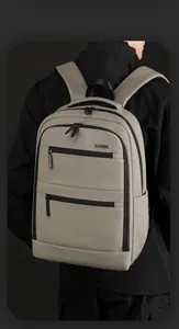 Detail view of the multi-compartment textured fabric backpack on model for business commute