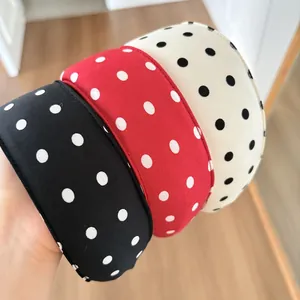 Detailed view of three polka dot sponge headbands in black, red, and beige colors