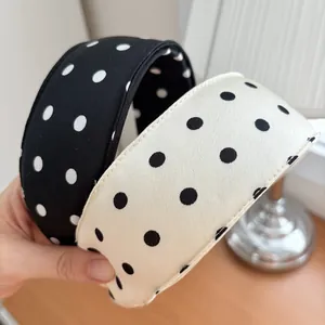Detailed close-up of wide polka dot sponge headbands with soft matte fabric texture