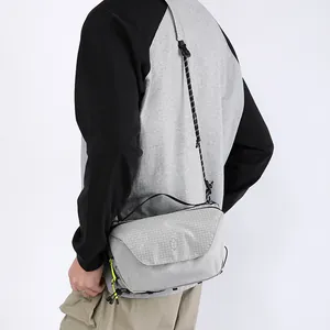 Minimalist grey techwear crossbody bag with grid texture fabric and yellow zippers