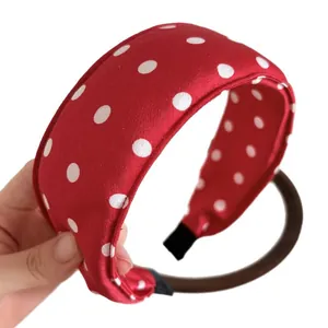 Classic French retro red polka dot wide sponge headband with silk texture held in hand
