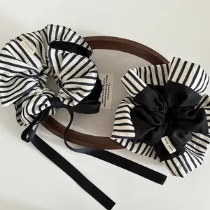 Détail de chouchous faits main à rayures noires et blanches avec nœuds en satin
