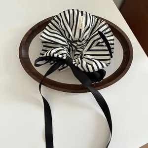 Détail de chouchou rayé avec long ruban satiné et étiquette handmade sur plateau bois