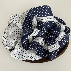 Detailaufnahme der dunkelblauen und weißen gepunkteten Scrunchies mit zarter Spitze am Rand