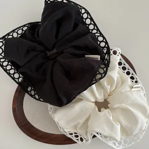 Detailed view of handmade fabric hair scrunchies with delicate hollow lace edges