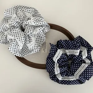 Marineblaue und weiße Polka-Dot-Haargummis mit Hohlspitzenbesatz in einem Tablett