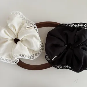 Lace-edged scrunchie set in black and ivory with handmade woven label for ponytail styling