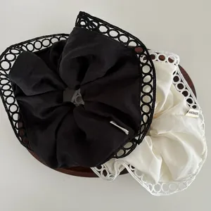 Lace-edged scrunchies in black and beige silk fabric with handmade label detail