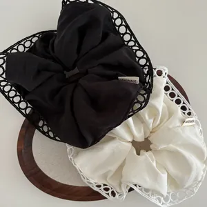 Lace-trimmed oversized hair scrunchie set in black and white with handmade label