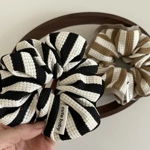 Macro shot of striped waffle fabric scrunchies with a cute baby label and soft texture