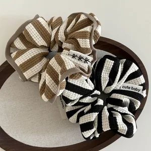 Close-up of striped cotton waffle texture hair scrunchies with cute baby fabric labels