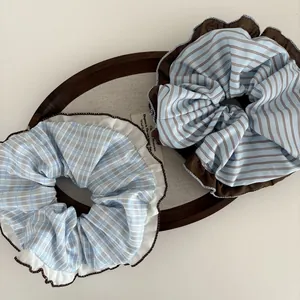 Detail of blue and brown striped oversized scrunchies with decorative ruffled edges