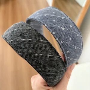 Detail showing two wide sponge headbands in black and blue with white polka dot patterns