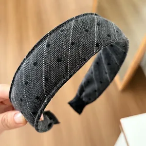 Close-up of wide sponge headband featuring dark grey denim fabric with white twill and black dots