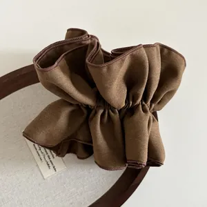 Macro di elastico per capelli in tessuto marrone a pieghe con trama twill e bordo rifinito