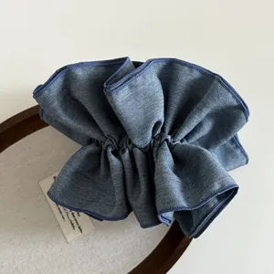 Vista dettagliata di un elastico per capelli in denim blu scuro con trama a pieghe