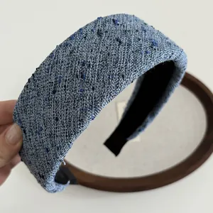 Détail du serre-tête en tweed bleu clair montrant sa texture épaisse et son tissu chic
