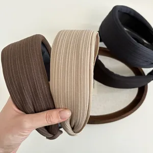 Close-up of ribbed knit headbands in dark brown, beige, navy and black with knot detail