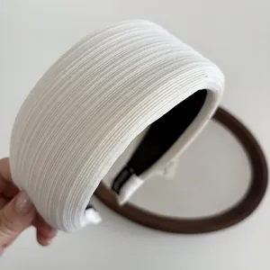 Detail view of white sponge headband with fine ribbed knit texture and non-slip lining