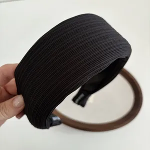 Detail view showing black ribbed fabric texture on a wide-brimmed padded headband