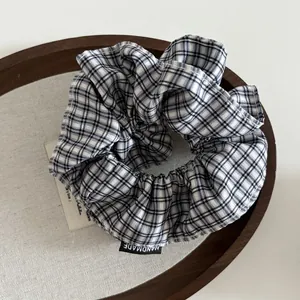 Gros plan d'un chouchou en tissu à carreaux avec étiquette faite main sur plateau