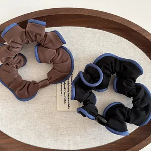 Elegant set of black and brown pleated fabric hair scrunchies with blue edge piping