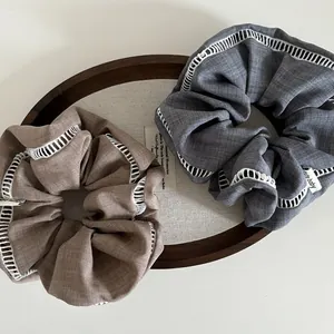 Minimalist large fabric scrunchies with white hollow lace trim in brown and grey-blue colors