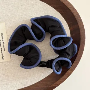 Elegant black scrunchie with blue ruffled edges and vintage aesthetic details