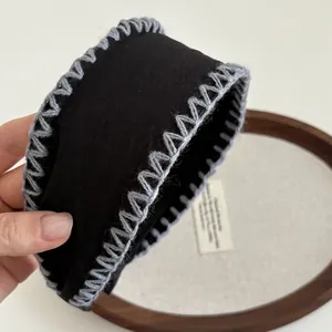 Detailed close-up of handmade wide headband featuring retro grey hand-stitched sawtooth edges
