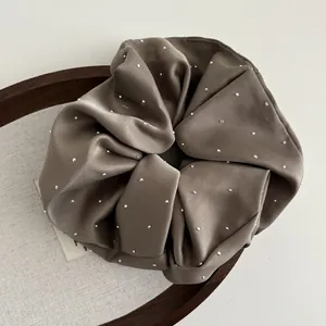 Detailed texture of oversized coffee satin scrunchie with sparkling silver rhinestones