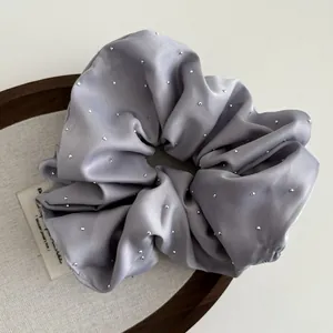 Detailed macro view of a lavender satin scrunchie with sparkling silver beads