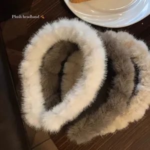 Detailed view of three plush wavy headbands in white, dark grey and khaki colors