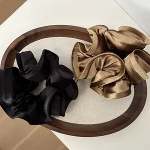 Detalle de elegantes coleteros de terciopelo extragrandes en negro y marrón dorado