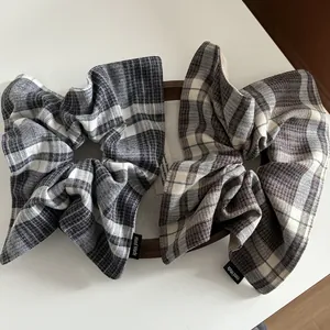 Detailed view of handmade plaid scrunchies in grey and brown flannel fabric textures
